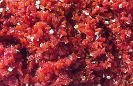 Minced red peppers and seeds, part way through a batch of hot sauce
